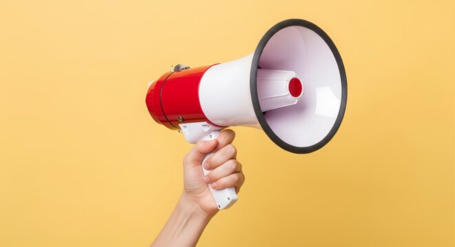 Hand holding a red and white megaphone on yellow background.
