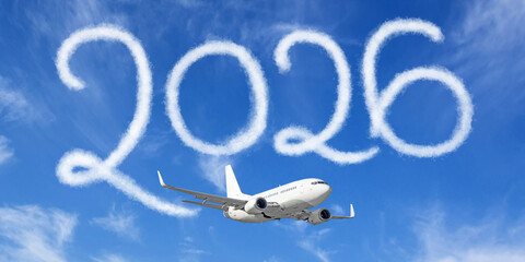 Happy New year 2026 concept enjoy travel on the blue background below cloudscape. Drawing by passenger airplane vapor steam contrail in sky.