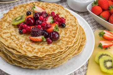Plato con crepes y kiwi, fresas y frutos rojos.