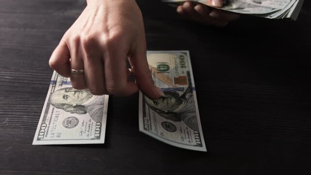 Woman Slowly Counting Us Dollars On A Table