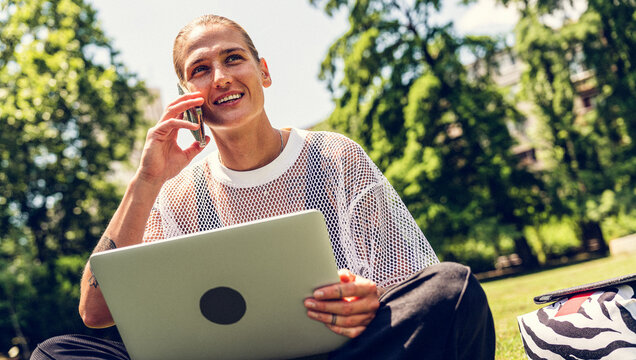 Digital nomad lifestyle, woman working on laptop and smartphone in park
