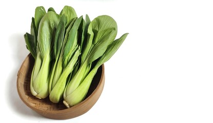 Fresh bok choy or pak choi or pakcoy (Brassica rapa subsp. chinensis) vegetables in bamboo bowl. Isolated on white background with copy space.