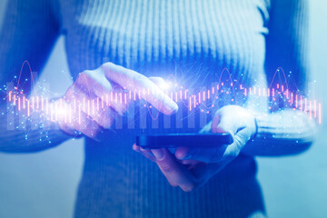 Business concept: hands holding phone, abstract analytics charts on blue background.