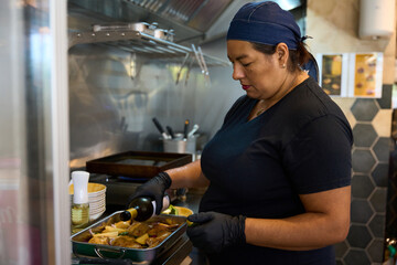 Woman chef adding wine to cooking dish