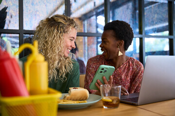 Diverse friends laughing enjoying lunch together