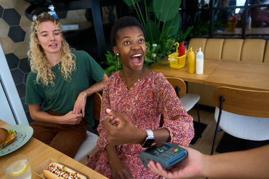 Woman paying contactless with smartwatch at restaurant