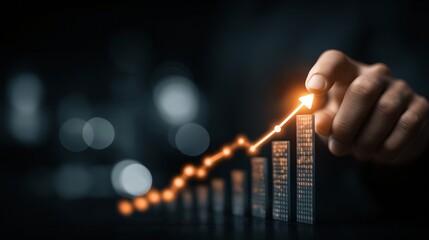 Hand reaches out to tap glowing arrow on bar graph, symbolizing business growth and success. dark background highlights bright, upward trend, conveying sense of optimism and achievement