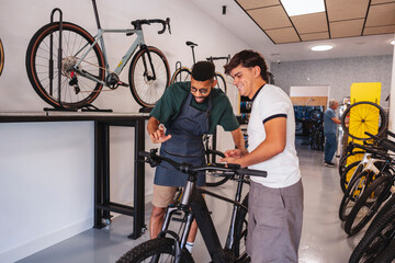 Salesperson helping customer choosing a new e bike © PintoArt