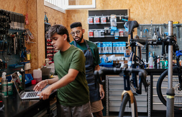 Bicycle shop mechanics using laptop for business management