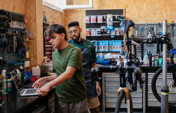 Bicycle shop mechanics using laptop for business management