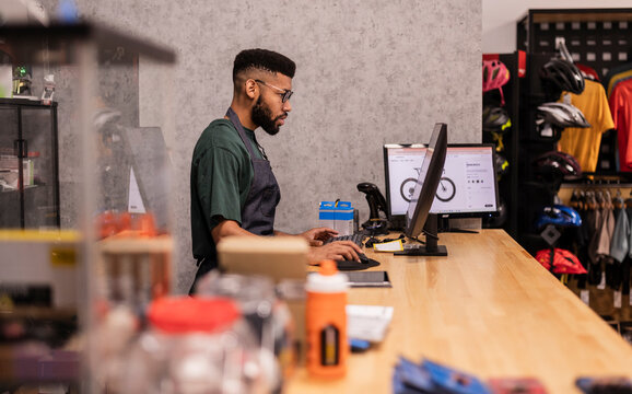 Bicycle shop owner working at point of sale computer