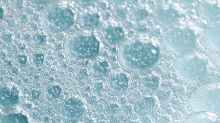 Obraz premium Bubbles of varying sizes emerge and float in a clear blue liquid creating a tranquil scene that showcases the beauty of bubbles and liquid dynamics.