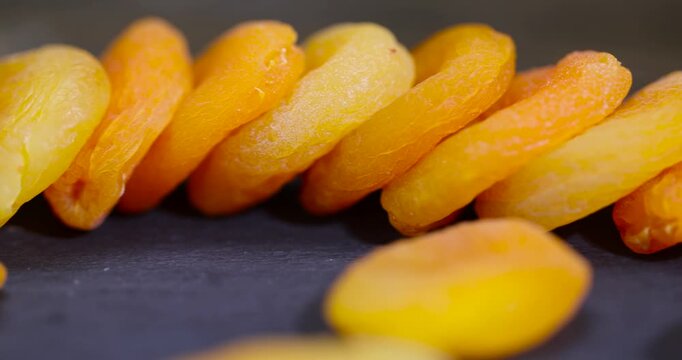 dried ripe orange apricot fruits on a black slate board, dried seedless pure dried apricots for long-term storage and used as a sweet or for making compotes