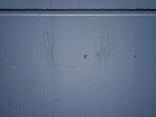 Grey concrete wall with handprints