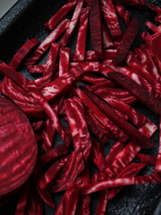 Julienned raw beetroot strips cut in matchstick style on dark surface