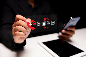 A person holding a transparent card displaying SOS symbols, indicating emergency services, while using a smartphone in a dark setting.