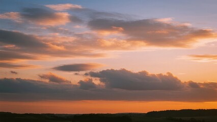 Obraz premium A vibrant sunset with orange and pink hues illuminating the sky above a distant horizon.