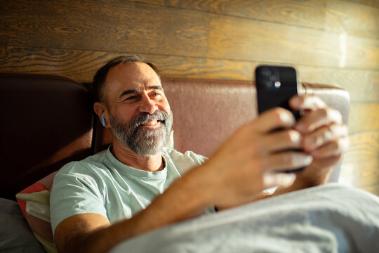 Man using smartphone in bed