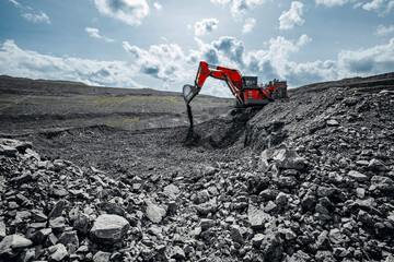 Heavy excavator machinery operating under cloudy sky, Open pit mine process, industry landscape.