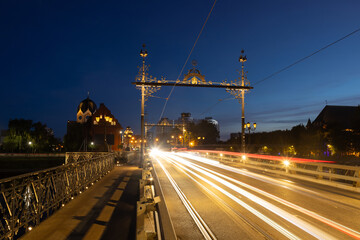 The glow of moving car lights on an evening across a Wooden bridge in Kaliningrad