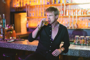 Handsome Blond Man Sipping Whiskey at Club Bar