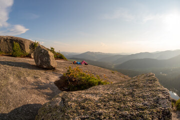 Woman hiker resting in mountain after climbing at sunset