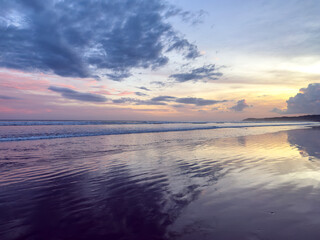 Obraz premium Colorful Sunset Reflections on Beach Shoreline 
