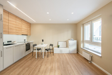 Modern Home Living Room and Kitchen Interior. Luxurious Stylish Modern Apartment. Open Interior, White Furniture, Windows. Scandinavian Design