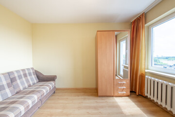 Fototapeta premium Minimalism Home Bedroom Interior. Closet, Hardwood Floor. Sofa, Couch. Heater and Window in Background