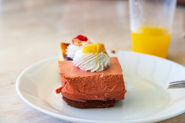 Fruit cake on a table, decorated with fresh strawberries, raspberries, and blueberries. A sweet homemade dessert served on a white plate, with a blurred background that highlights the cake details.