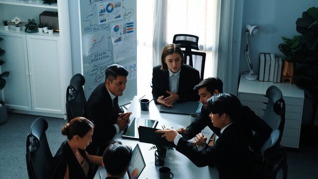 Top view of manager looking at financial statistic chart on tablet at meeting room. Group of business people working together to analyze investment data and planning financial strategy. Directorate.