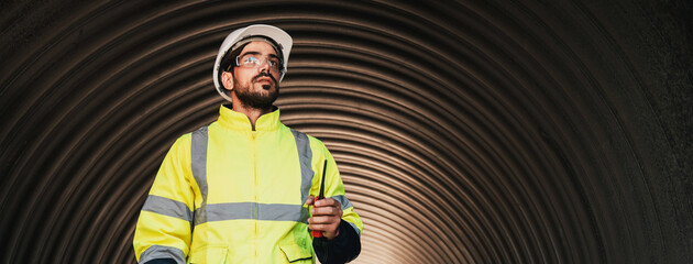 Workers inside a big steel pipe building a pipeline for oil, gas, and fuel at an industrial site.