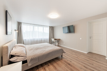 Luxurious master home bedroom interior, modern house, beautiful interiors, wide bedroom. TV Set on the Wall. 