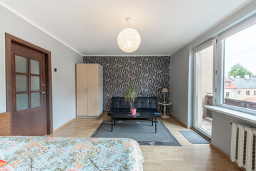 Fototapeta premium Home Living Room and Bedroom. Windows, Stylish Retro Style Apartment. Open Space Interior, Sofa, Couch and Closet, Wardrobe. Hardwood Floor and Carpet. Coffee Table and Flower.
