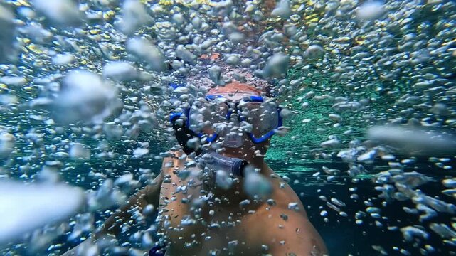 The snorkeler delights in the bubbling breath of the spring.
