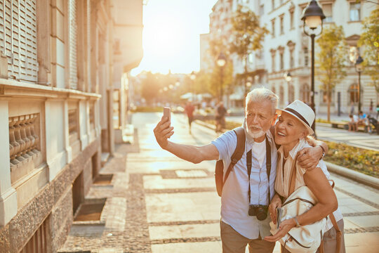 Senior couple taking selfie in city