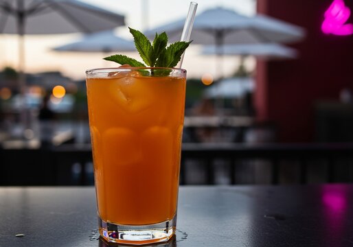 Vibrant Orange Cocktail with Mint on a Rooftop Bar Patio at Dusk with Pink Neon