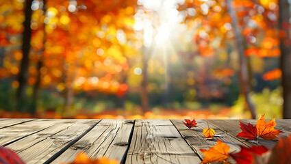 Wooden table with autumn leaves and sunlit forest background