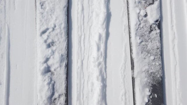 Captivating Top-Down View of Skis and Snow on a Bright Winter Day, Illustrating the Serene Beauty of Mountain Sports and Alpine Adventures with Fresh Powder on the Slopes, Ready for Thrilling Descents