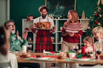 Family celebrating christmas dinner, serving roasted turkey