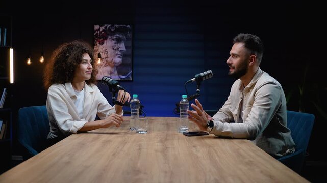 Podcast presenters interviewing a guest in a modern radio studio