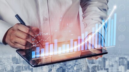 A business professional actively analyzes data trends on a tablet, showcasing a vibrant graphic...