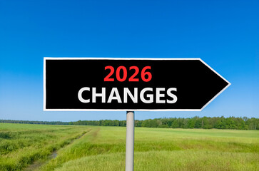 2026 Changes symbol. Concept words 2026 Changes on beautiful black road sign. Beautiful green grass field forest and blue sky background. Business and 2026 changes concept. Copy space.