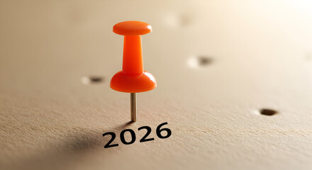 Year 2026 marked with an orange pushpin on a notice board. Concept for future planning, setting goals, scheduling events, or saving the date for a special occasion.