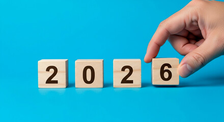 Planning for a successful 2026 with wooden blocks on a vibrant blue background future concept