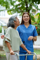 Caring caregiver provides assistance and support to senior in need of care while enjoying pleasant outdoor moment together