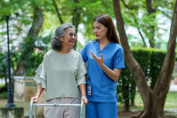 Caring caregiver provides assistance and support to senior in park, fostering warm connection while ensuring comfort and safety during their walk
