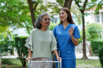 Caring caregiver provides assistance and support to senior in park, fostering warm connection and ensuring comfort during their time together