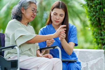 Caring caregiver provides assistance and support to senior in need of care while sitting outdoors. warm interaction highlights importance of compassion in caregiving