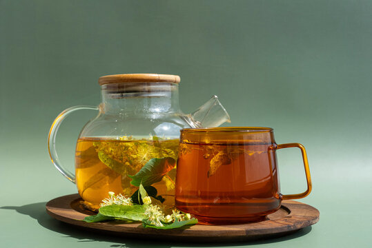 Glass teapot and cup with herbal linden tea